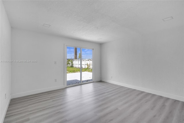 8330 NW 35th Pl, Miami, FL 33147 - empty room featuring wood finished floors, baseboards, and a textured ceiling