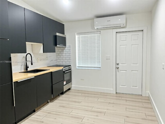 16204 NE 18th Ct, North Miami Beach, FL 33162 - kitchen featuring an AC wall unit, a sink, stainless steel range with electric stovetop, light countertops, and light wood finished floors