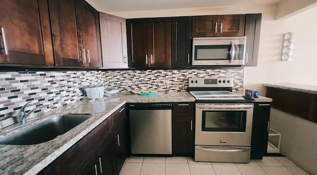 2025 NE 164th St Unit 506, North Miami Beach, FL 33162 - kitchen with appliances with stainless steel finishes, backsplash, and light stone counters