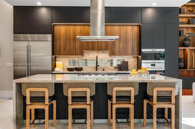 2805 Freeman St, Miami, FL 33133 - kitchen featuring island range hood, modern cabinets, backsplash, light stone counters, and recessed lighting