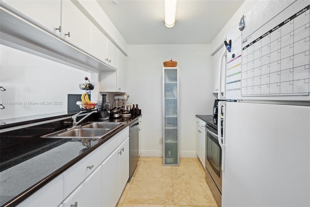 2475 Brickell Ave Unit 1805, Miami, FL 33129 - kitchen featuring stainless steel appliances, a sink, dark countertops, white cabinetry, and baseboards