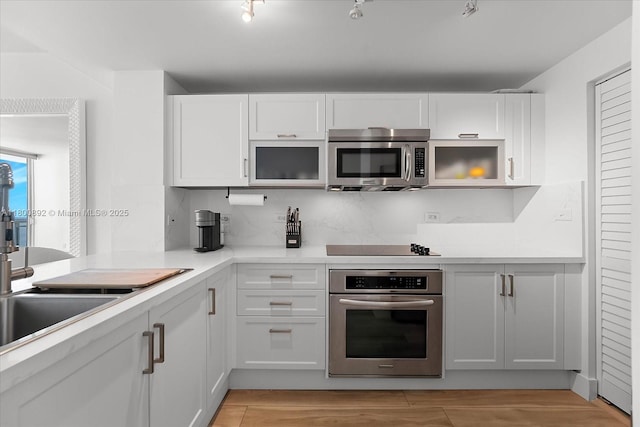 244 Biscayne Blvd Unit 2407, Miami, FL 33132 - kitchen with appliances with stainless steel finishes, white cabinetry, light countertops, and light wood-style floors