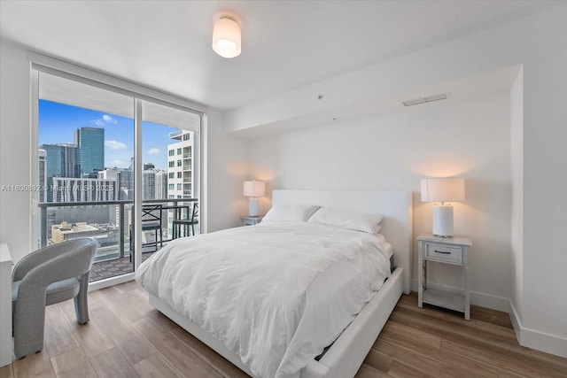 244 Biscayne Blvd Unit 2407, Miami, FL 33132 - bedroom with a wall of windows, access to exterior, wood finished floors, and a view of city