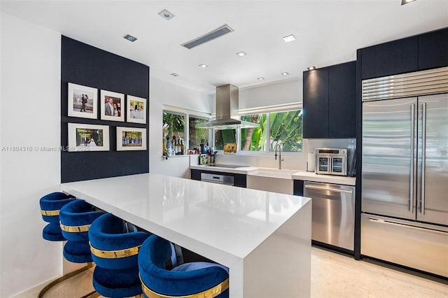 1024 Lenox Ave Unit 8, Miami Beach, FL 33139 - kitchen with stainless steel appliances, island range hood, dark cabinets, light countertops, and a breakfast bar area