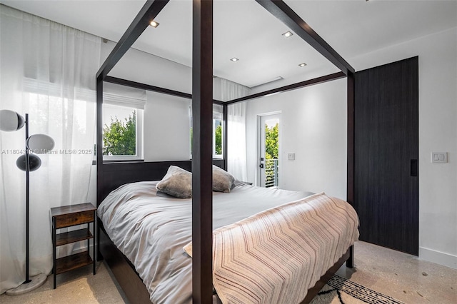 1024 Lenox Ave Unit 8, Miami Beach, FL 33139 - bedroom featuring multiple windows, access to outside, baseboards, and dark aggregate flooring