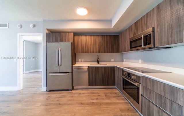 488 NE 18th Unit 2703, Miami, FL 33132 - kitchen with stainless steel appliances, a sink, modern cabinets, light countertops, and light wood-style flooring