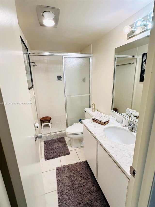 4750 S Ocean Blvd Unit 401, Highland Beach, FL 33487 - full bathroom with tile patterned floors, a shower stall, toilet, and vanity