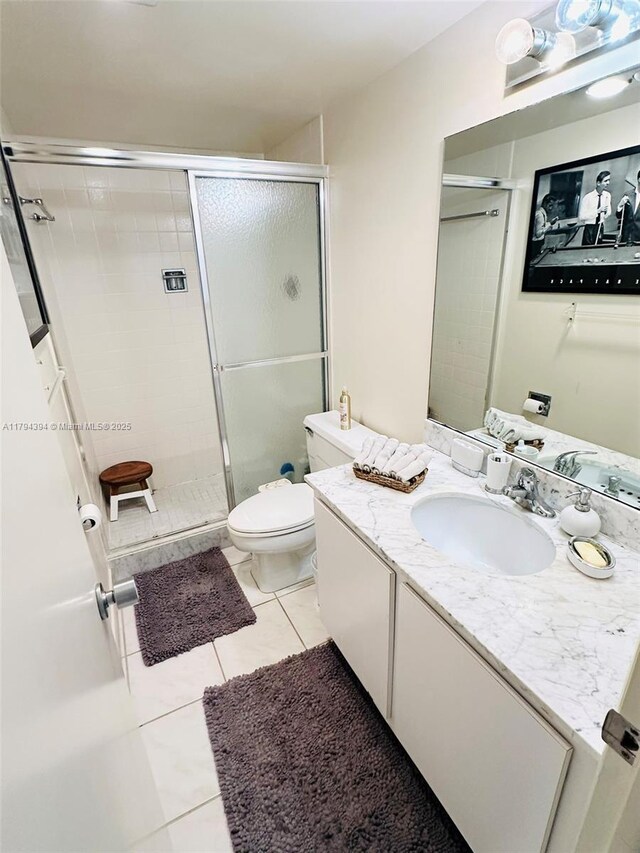4750 S Ocean Blvd Unit 401, Highland Beach, FL 33487 - bathroom featuring a shower stall, tile patterned floors, vanity, and toilet