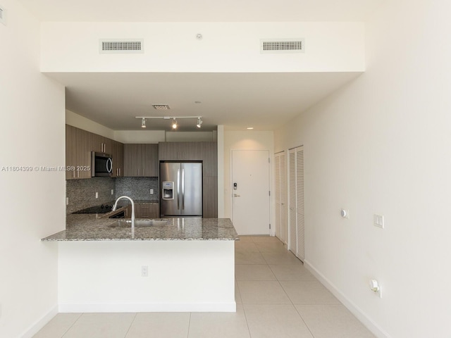 5350 NW 84th Ave Unit 1018, Doral, FL 33166 - kitchen featuring stainless steel appliances, a peninsula, a sink, tasteful backsplash, and light stone countertops
