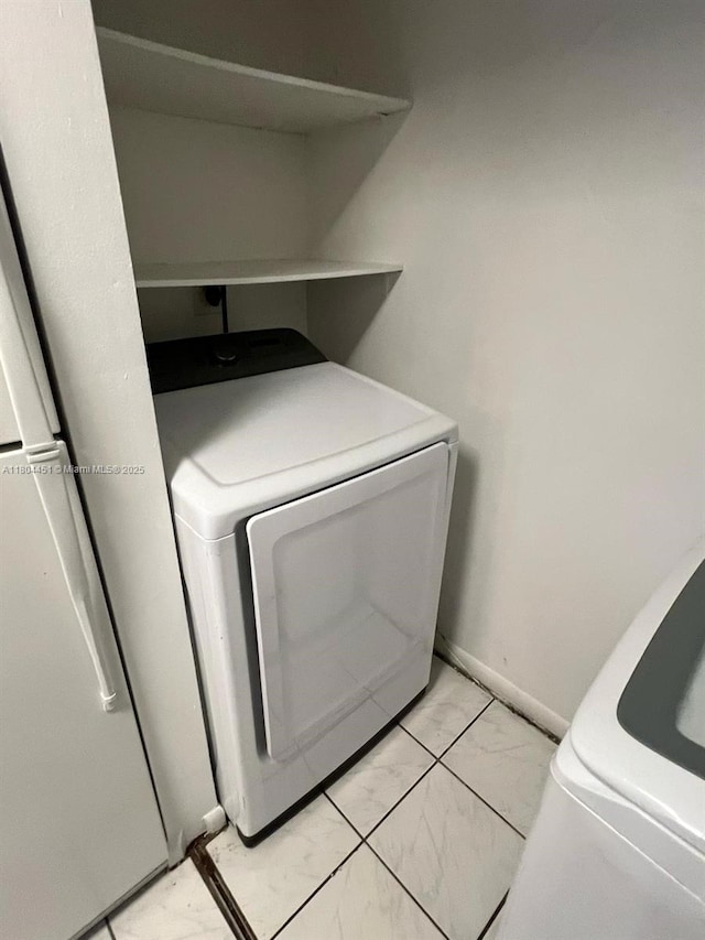 927 NE 199th St Unit 102, Miami, FL 33179 - laundry area featuring washer / clothes dryer, light marble finish flooring, and baseboards