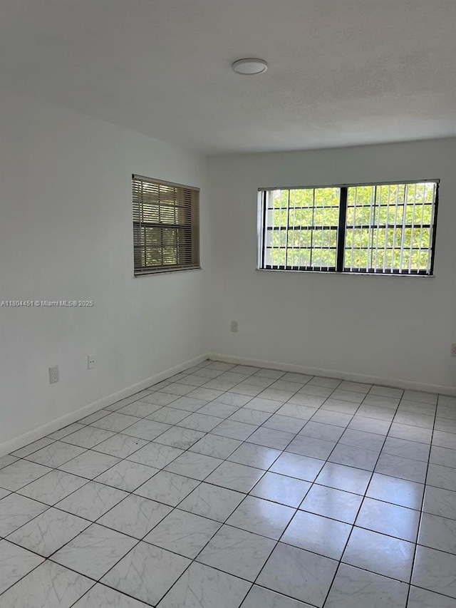 927 NE 199th St Unit 102, Miami, FL 33179 - unfurnished room featuring plenty of natural light and baseboards