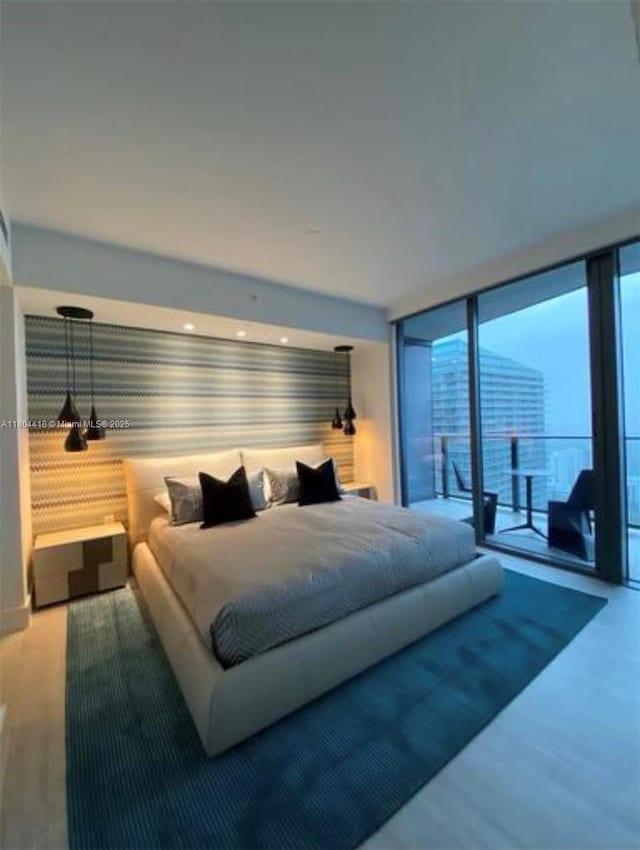 1000 Brickell Plz Unit 3308, Miami, FL 33131 - bedroom featuring wallpapered walls, a wall of windows, multiple windows, and wood finished floors