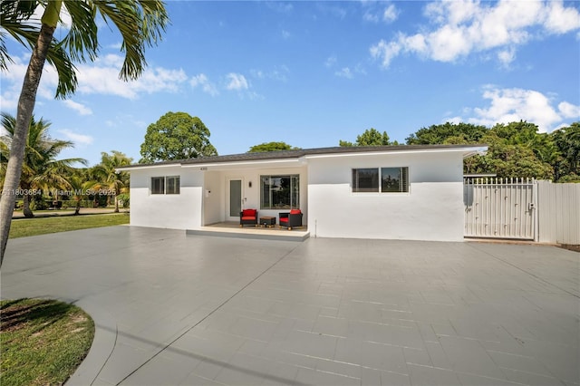 4301 SW 85th Ave, Miami, FL 33155 - view of front of home with stucco siding, a gate, concrete driveway, and a patio