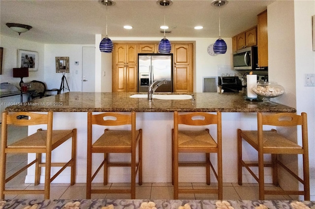 2555 Collins Ave Unit 308, Miami Beach, FL 33140 - kitchen with appliances with stainless steel finishes, a sink, a breakfast bar area, a peninsula, and recessed lighting