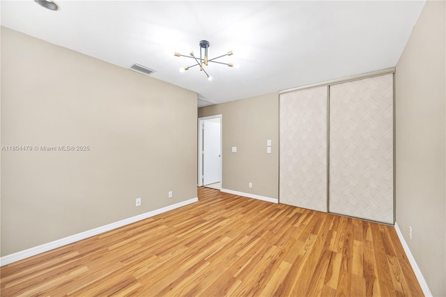 2717 N Carambola Cir N Unit 17101, Coconut Creek, FL 33066 - unfurnished bedroom with a chandelier, light wood-type flooring, baseboards, and a closet