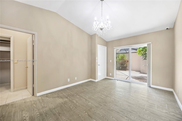 2717 N Carambola Cir N Unit 17101, Coconut Creek, FL 33066 - unfurnished room with lofted ceiling, a chandelier, wood finished floors, and baseboards