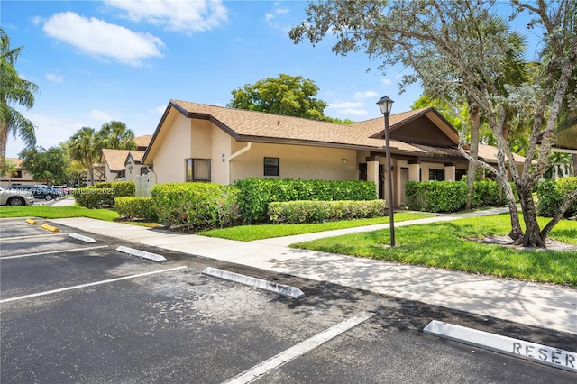 2717 N Carambola Cir N Unit 17101, Coconut Creek, FL 33066 - view of front facade with uncovered parking, stucco siding, and a front lawn