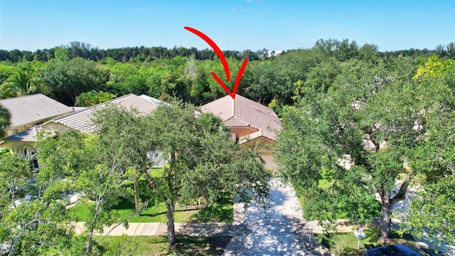 aerial view of property and surrounding area with a heavily wooded area