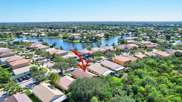 aerial view of property and surrounding area featuring nearby suburban area and a large body of water