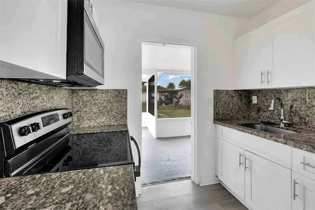 15351 SW 296th St, Homestead, FL 33033 - kitchen with a sink, stainless steel range with electric cooktop, dark stone countertops, white cabinets, and backsplash
