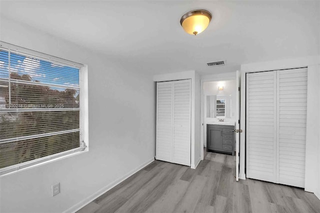 15351 SW 296th St, Homestead, FL 33033 - unfurnished bedroom with wood finished floors, baseboards, multiple closets, and a sink