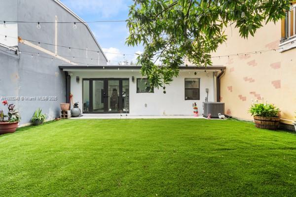 1594 W 73rd St, Hialeah, FL 33014 - back of house featuring a lawn, central air condition unit, french doors, and stucco siding