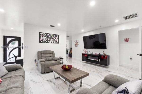 living room featuring marble finish flooring, recessed lighting, and baseboards