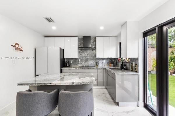 1594 W 73rd St, Hialeah, FL 33014 - kitchen with wall chimney exhaust hood, a sink, freestanding refrigerator, a kitchen island, and tasteful backsplash