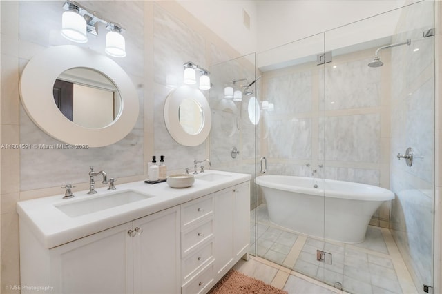 5860 La Gorce Dr, Miami Beach, FL 33140 - full bath featuring tile walls, a freestanding tub, double vanity, a stall shower, and tile patterned floors