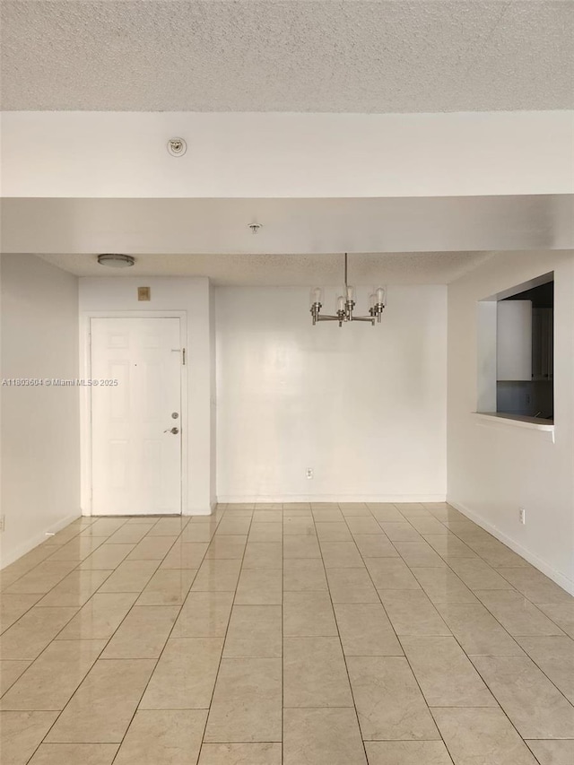 1450 SE 3rd Ave Unit 208, Dania Beach, FL 33004 - spare room featuring light tile patterned floors, baseboards, a textured ceiling, and a chandelier