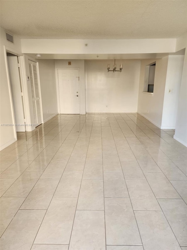 1450 SE 3rd Ave Unit 208, Dania Beach, FL 33004 - empty room featuring light tile patterned floors, a chandelier, and a textured ceiling