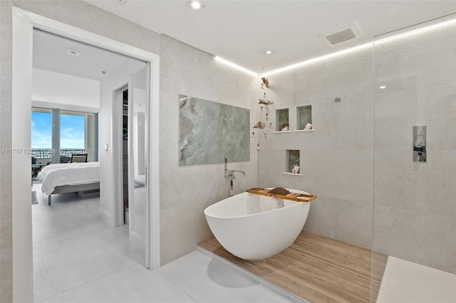 3400 SW 27th Ave Unit 1102, Miami, FL 33133 - full bath featuring a freestanding tub, connected bathroom, tile patterned floors, and recessed lighting