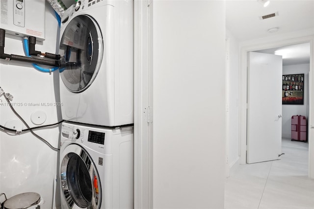 3400 SW 27th Ave Unit 1102, Miami, FL 33133 - laundry room with estacked washer and dryer, light tile patterned floors, and water heater