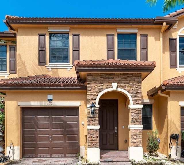 380 NE 37th Ter, Homestead, FL 33033 - view of property featuring a garage, stone siding, stucco siding, and a tile roof