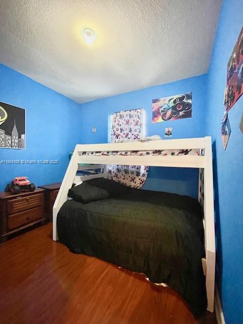 380 NE 37th Ter, Homestead, FL 33033 - bedroom with wood finished floors and a textured ceiling