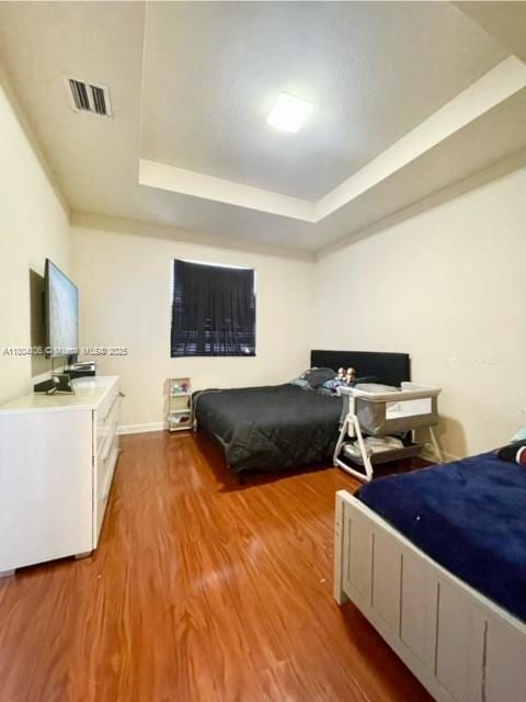 380 NE 37th Ter, Homestead, FL 33033 - bedroom with a tray ceiling and wood finished floors