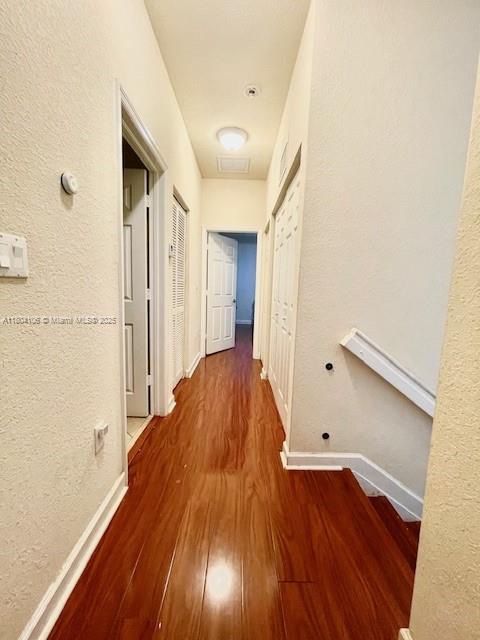 380 NE 37th Ter, Homestead, FL 33033 - corridor with wood finished floors, baseboards, and a textured wall