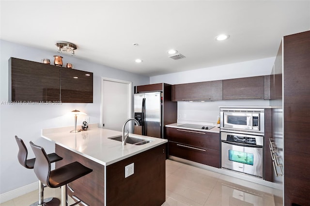 1900 N Bayshore Dr Unit 2512, Miami, FL 33132 - kitchen featuring appliances with stainless steel finishes, a sink, dark brown cabinets, a breakfast bar area, and recessed lighting