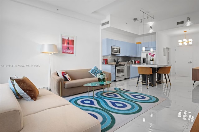 living area with light marble finish flooring and track lighting