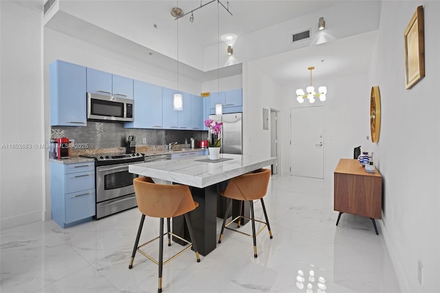 kitchen with appliances with stainless steel finishes, light marble finish floors, a kitchen breakfast bar, decorative backsplash, and blue cabinetry