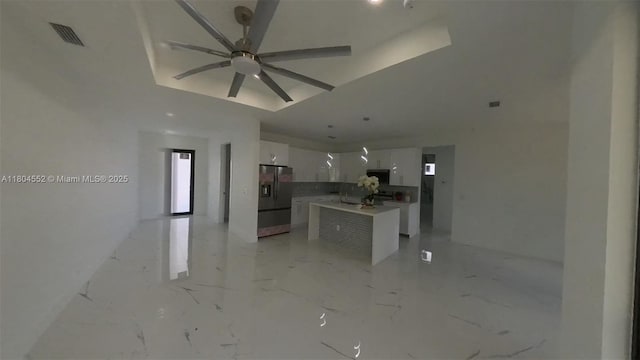 3004 SW 4th St, Lehigh Acres, FL 33976 - kitchen with stainless steel fridge with ice dispenser, white cabinetry, a ceiling fan, light marble finish floors, and modern cabinets