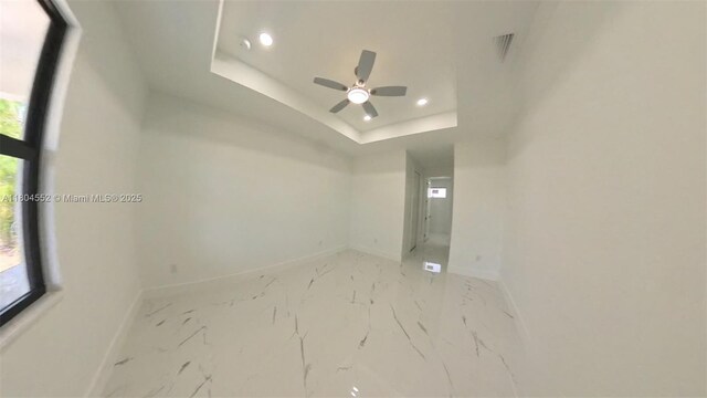 3004 SW 4th St, Lehigh Acres, FL 33976 - spare room featuring baseboards, recessed lighting, a ceiling fan, a tray ceiling, and light marble finish flooring