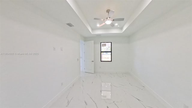 3004 SW 4th St, Lehigh Acres, FL 33976 - spare room with baseboards, a raised ceiling, ceiling fan, and light marble finish flooring