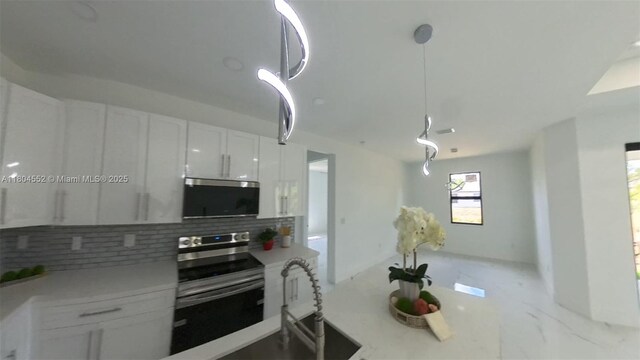 3004 SW 4th St, Lehigh Acres, FL 33976 - kitchen featuring appliances with stainless steel finishes, decorative backsplash, white cabinetry, light marble finish flooring, and light countertops