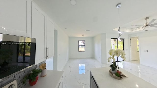 3004 SW 4th St, Lehigh Acres, FL 33976 - unfurnished living room featuring light marble finish floors, ceiling fan, and baseboards