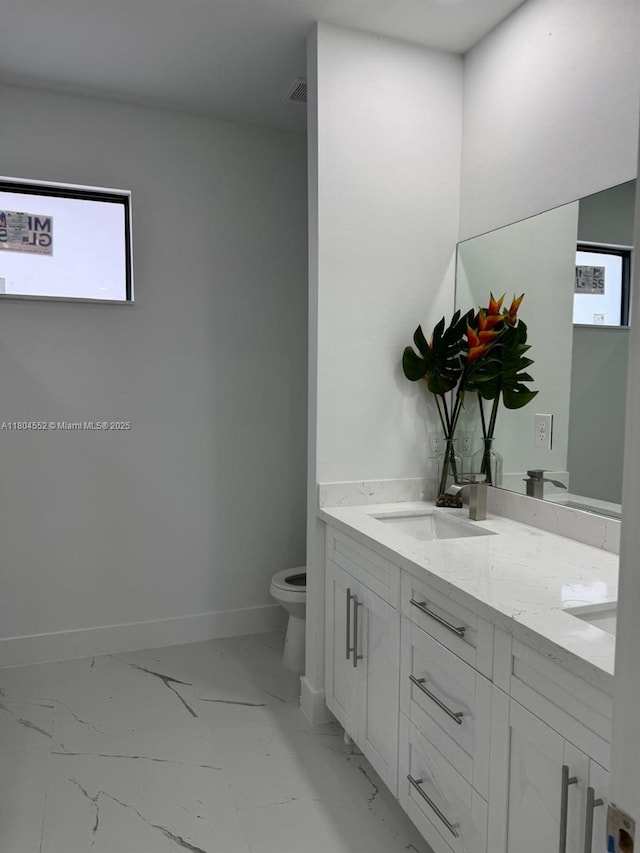 3004 SW 4th St, Lehigh Acres, FL 33976 - full bathroom with marble look tiles, toilet, baseboards, and double vanity