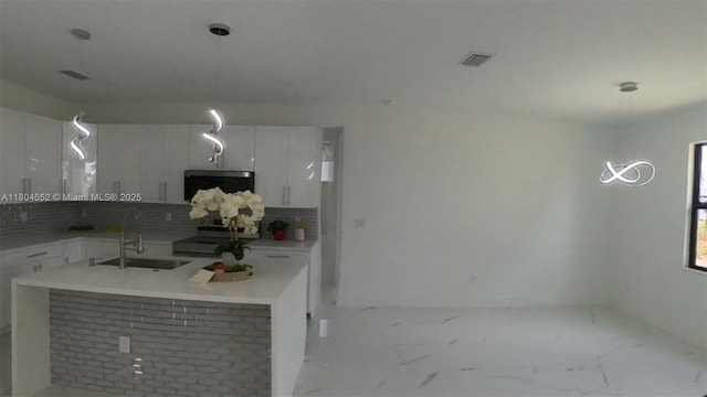 3004 SW 4th St, Lehigh Acres, FL 33976 - kitchen featuring a sink, stove, backsplash, and white cabinetry