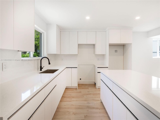 2039 NE 172nd St, North Miami Beach, FL 33162 - kitchen featuring a sink, white cabinetry, recessed lighting, light wood-type flooring, and modern cabinets
