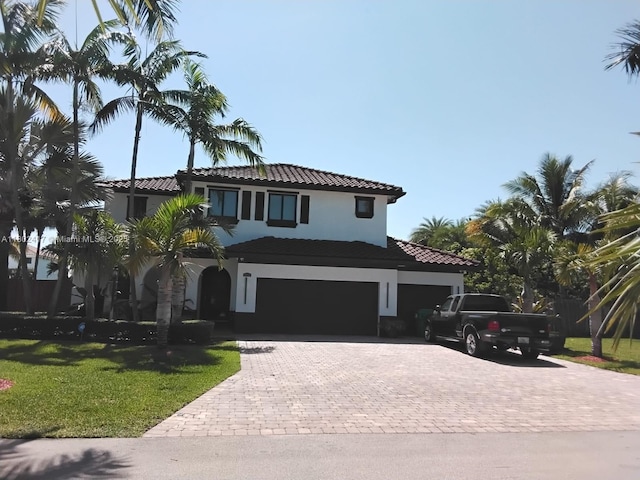 21046 SW 133rd Ct, Miami, FL 33177 - mediterranean / spanish house featuring a tile roof, decorative driveway, stucco siding, a front lawn, and a garage