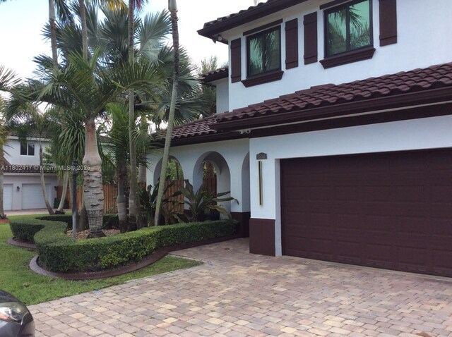 21046 SW 133rd Ct, Miami, FL 33177 - mediterranean / spanish-style home featuring stucco siding, decorative driveway, a tiled roof, and a garage